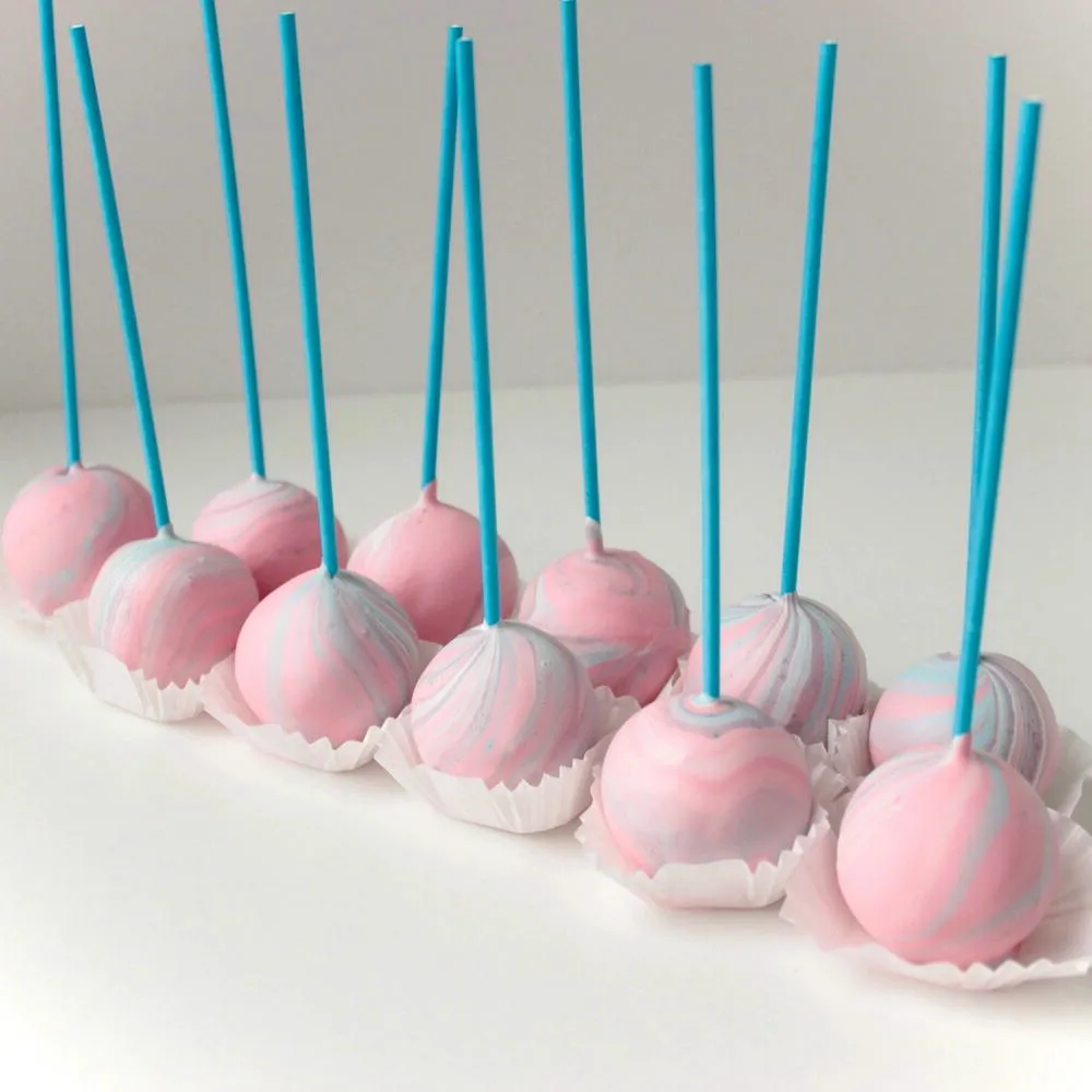 Pastel pink cake pops arranged in paper cups with blue sticks - Popcakes Ottawa