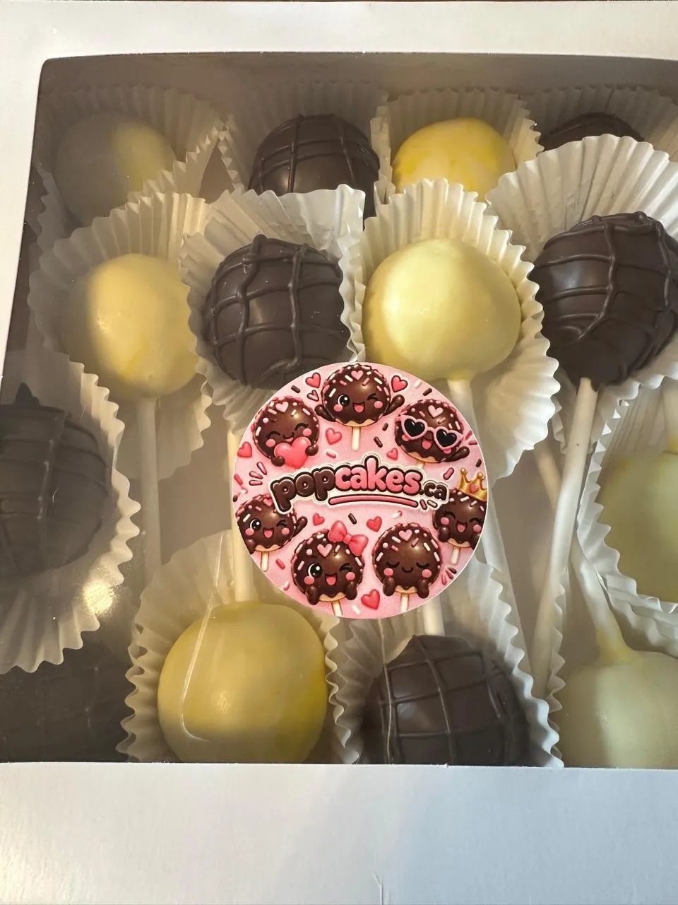 Chocolate and yellow cake pops in a box with Popcakes sticker - Popcakes Ottawa