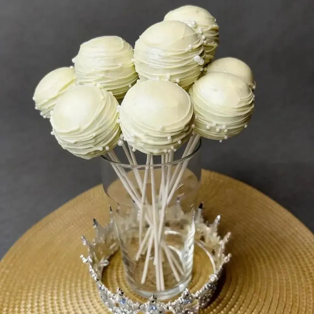 Ivory cake pops with contrasting drizzle displayed in a glass - Popcakes Ottawa