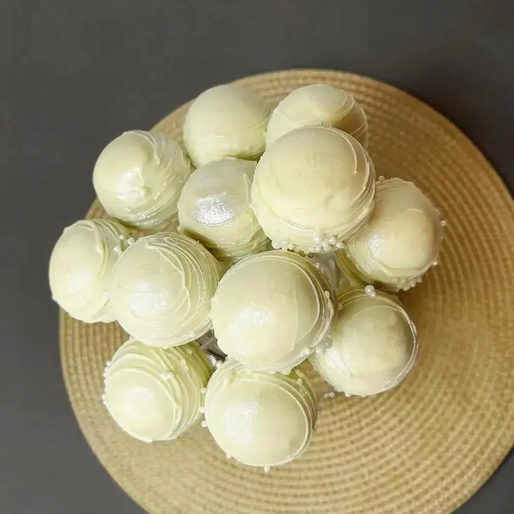 Overhead view of ivory-coated cake pops in a glass display - Popcakes Ottawa