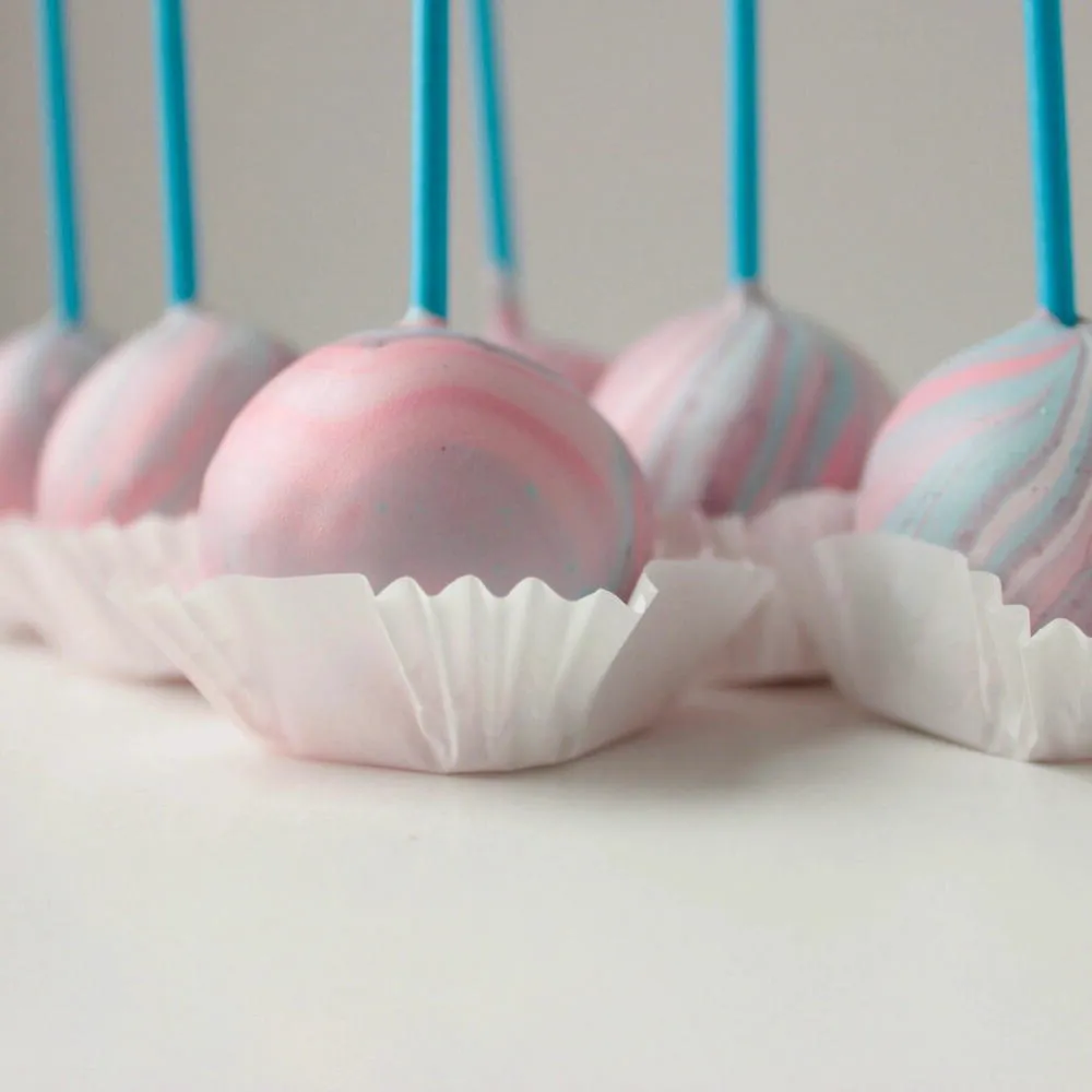 Close-up of pastel pink swirl cake pops in white paper cups - Popcakes Ottawa