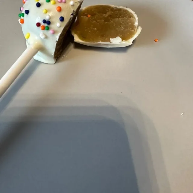 Vanilla cake pop with rainbow sprinkles cut in half - Popcakes Ottawa