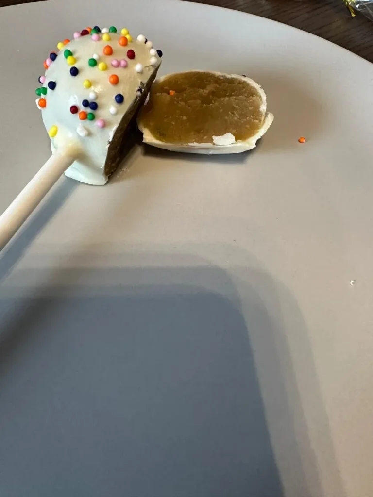 Vanilla cake pop with rainbow sprinkles cut in half - Popcakes Ottawa