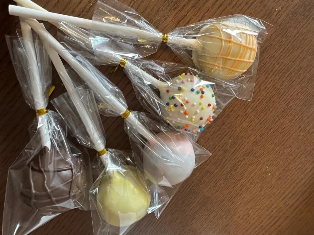 Close-up of wrapped cake pop favours with gold ties - Popcakes Ottawa